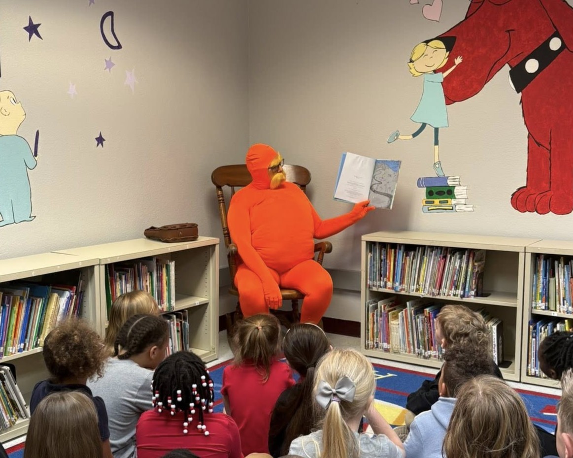 Debra Hogue as the Lorax, reading to students at SJLS for Dr. Seuss's Birthday Book-a-thon